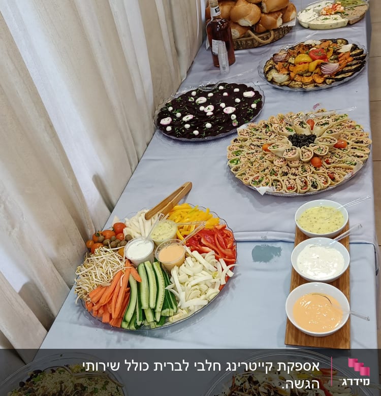 מגשי ירקות, סלטים ולחמניות על שולחן קייטרינג